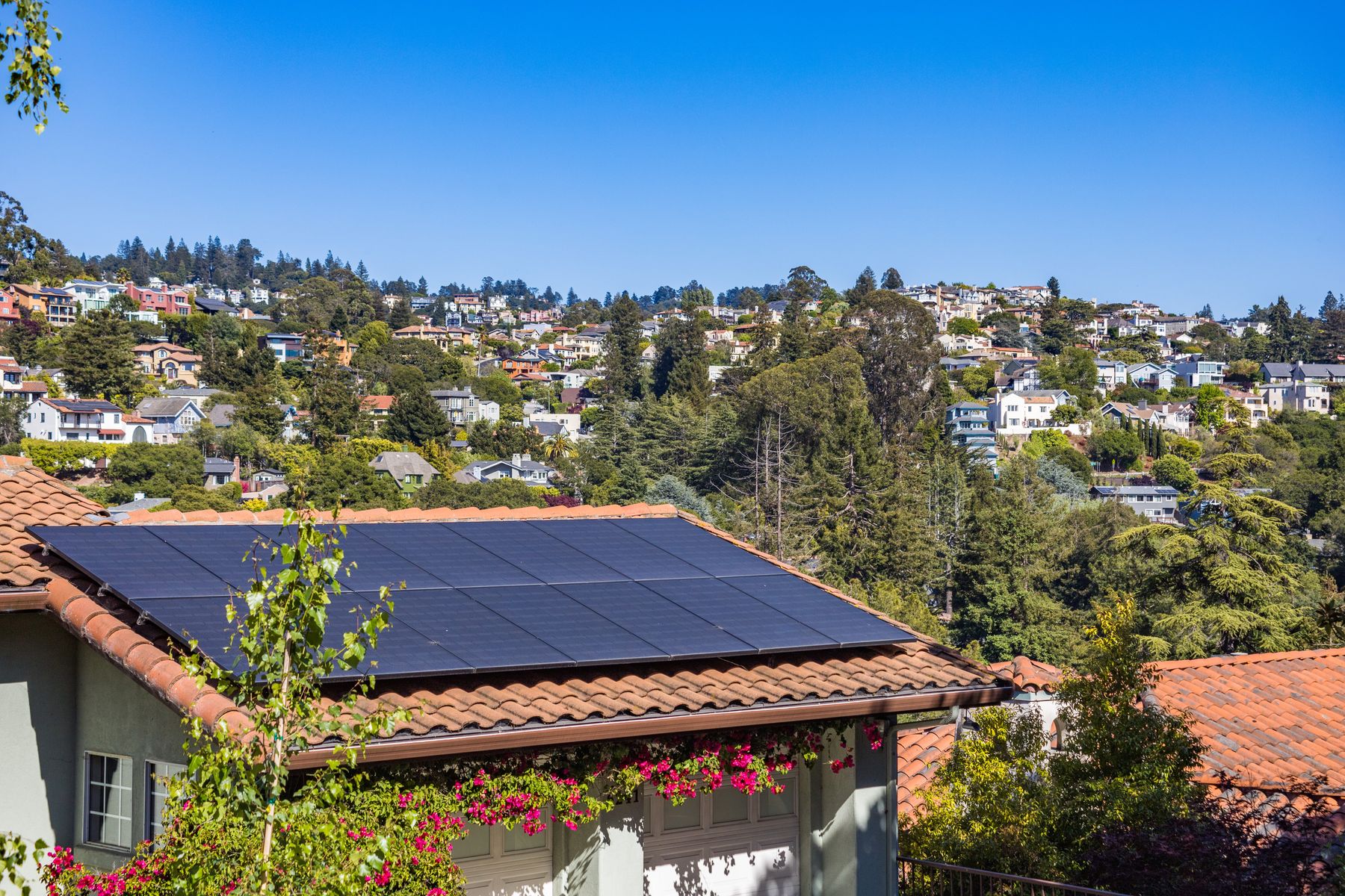 Rooftop solar array on a hillside home, photo by Robert So on Pexels