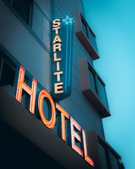 A colorful neon sign displaying 'Starlite Hotel' on a building exterior during dusk, creating a vibrant atmosphere.