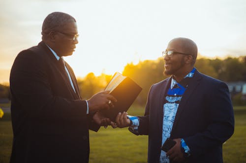 Men in Black Suit Holding Black Book 