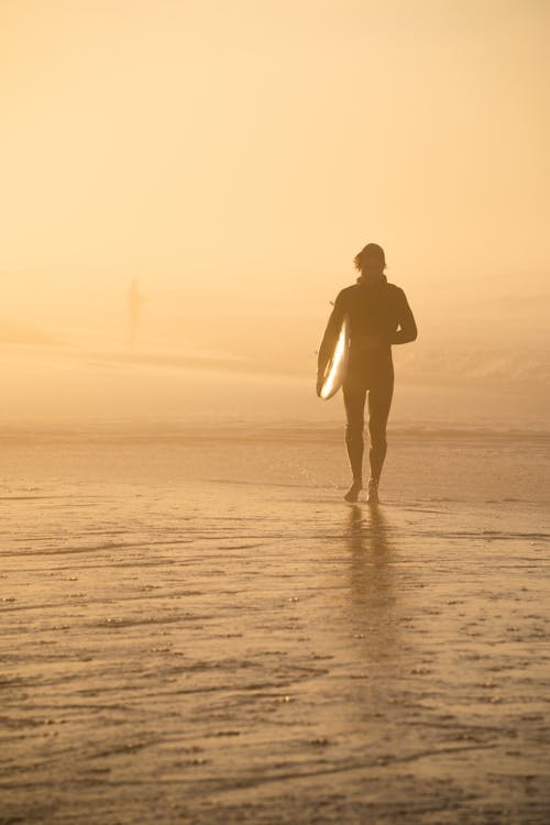 A Person Carrying a Surfboard