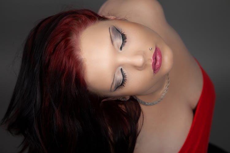 A Woman In Red Tube Top With Piercing Near Her Lips