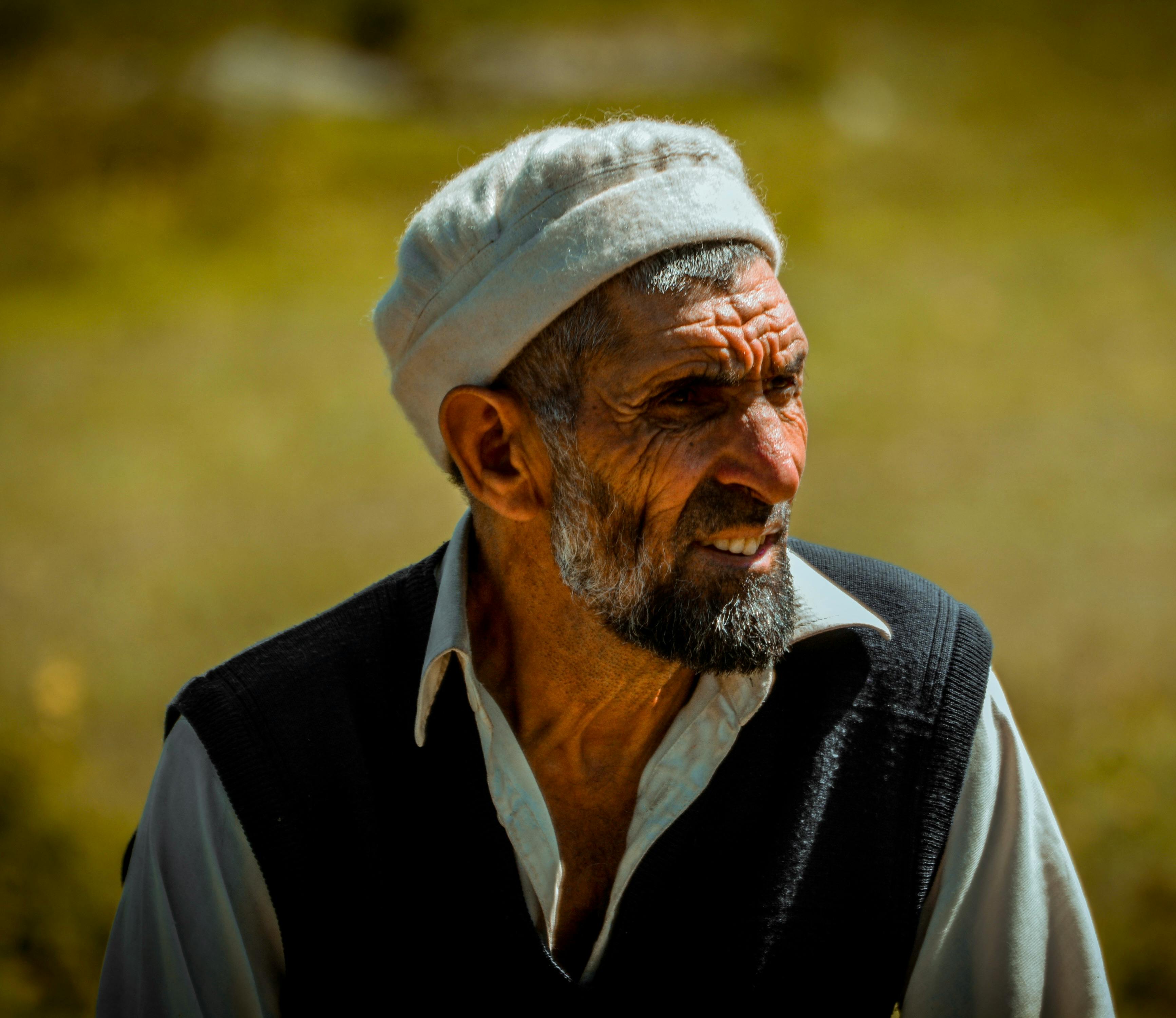 An Elderly Man in Black Sweater Vest Wearing a Cap · Free Stock Photo