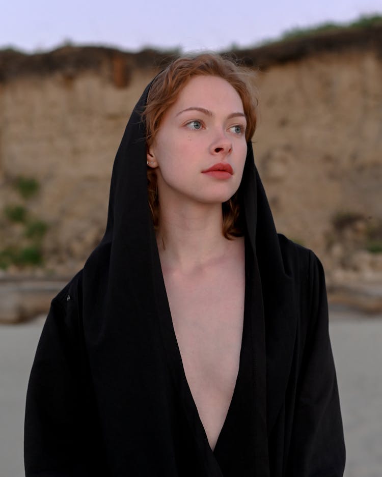 Attractive Redhead Woman Wearing Only Hooded Black Coat