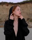 Redhead Woman in Black Hooded Coat Looking Around