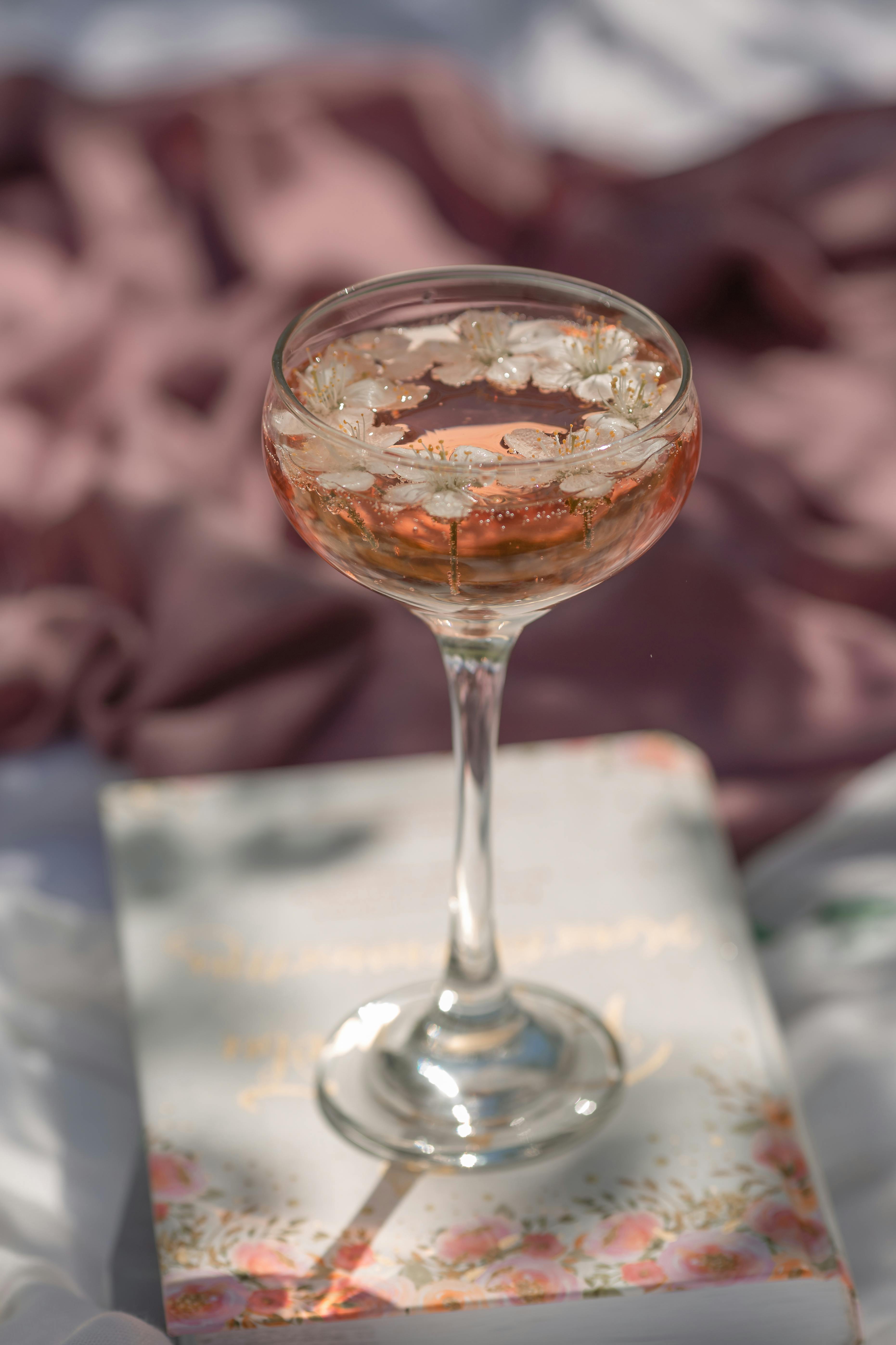 A delicate cocktail glass with floral decorations, ideal for outdoor parties or celebrations.