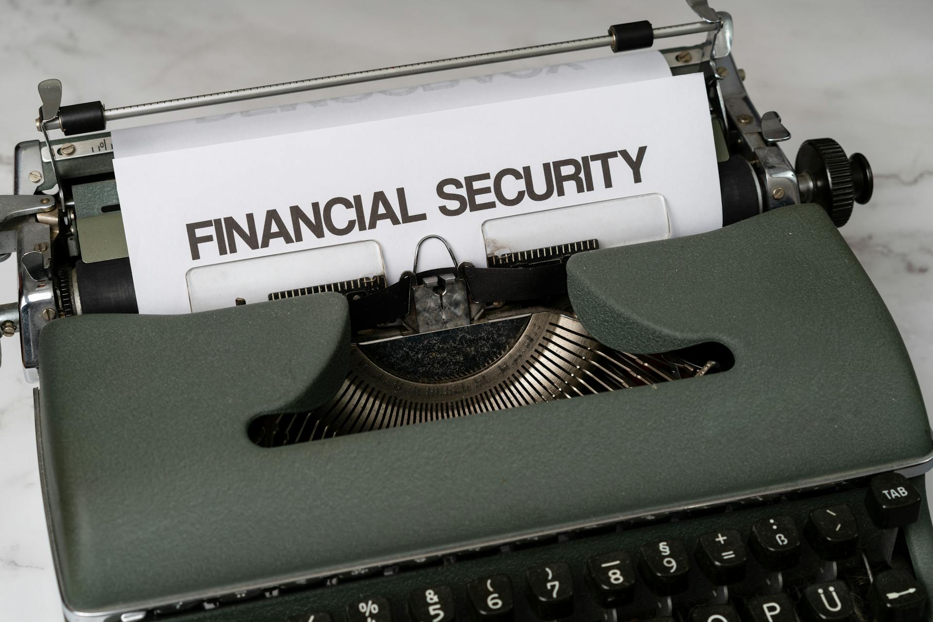 Close-up of a vintage typewriter with 'Financial Security' typed on paper, representing financial themes.