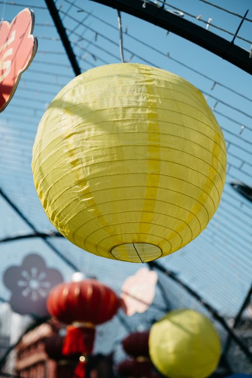 Free Yellow paper lanterns strung up outdoors, celebrating a cultural festival under a clear sky. Stock Photo