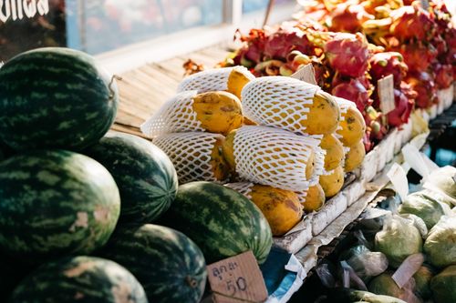 Free A vibrant assortment of watermelons, papayas, and dragon fruits at an outdoor market stall. Stock Photo