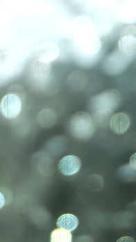A vertical shot of blurred bokeh circles creating an abstract light pattern in monochrome tones.