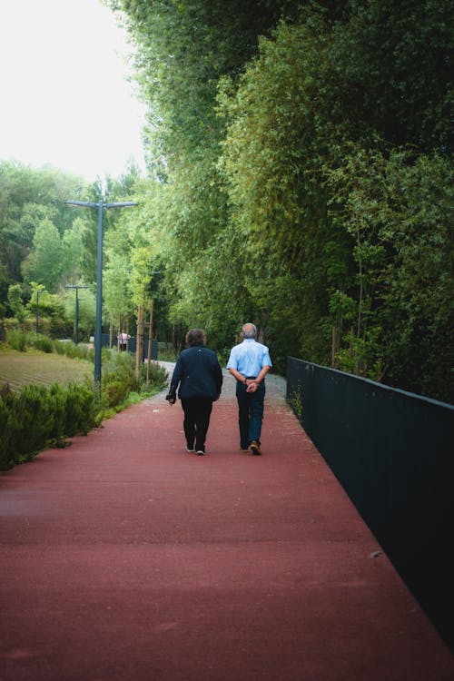 A Back View of a Couple Walking on the Street