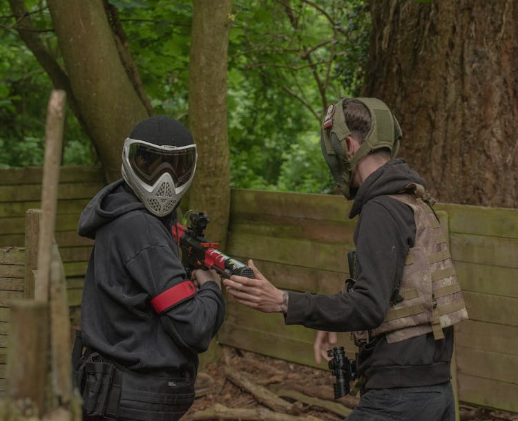 People Wearing Masks Holding Paintball Gun 