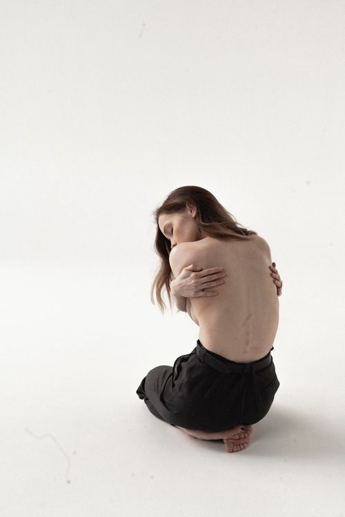 Free Serene portrait of a woman embracing herself, showcasing a minimalist and artistic style Stock Photo