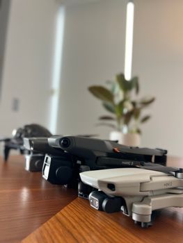 A selection of drones displayed on a sleek wooden table indoors.
