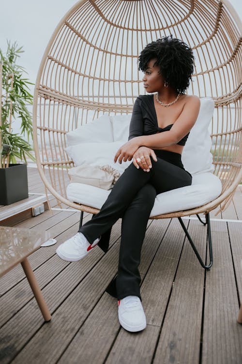 Woman in Brown Tank Top Sitting on White Chair