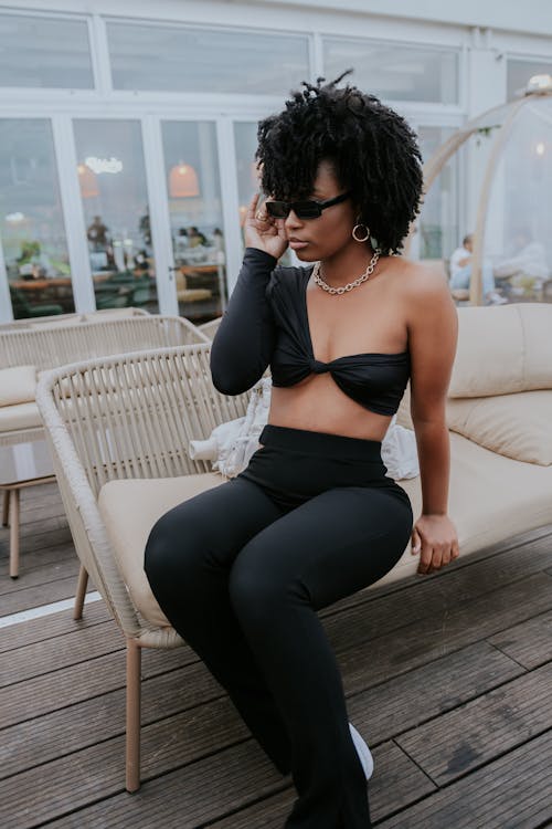 Woman in Black Brassiere and Black Leggings Sitting on Brown Wooden Bench