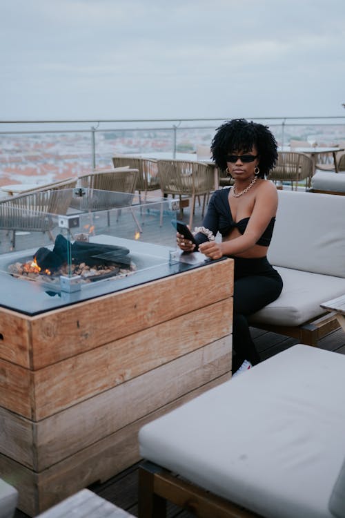 Woman in Black Tank Top Sitting on Brown Wooden Bench