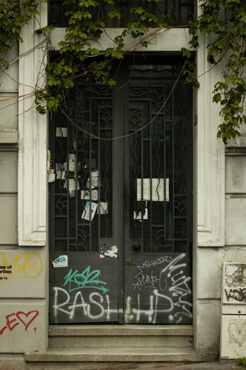 Free Rustic door with intricate ironwork decorated with vibrant graffiti in Istanbul. Urban charm and history. Stock Photo