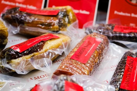 Close-up of assorted packaged Spanish cured meats with visible labels and textures.