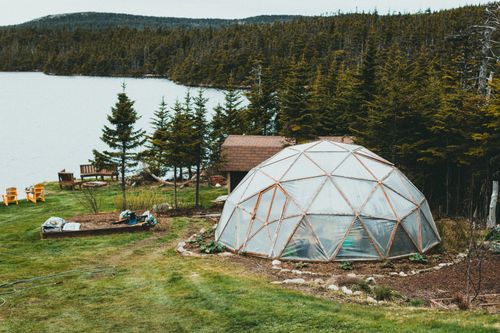 Free A geodesic dome in a lush forest setting, beside a serene lakeshore, offering a tranquil retreat vibe. Stock Photo