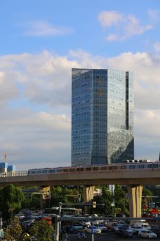 Urban scene with a towering skyscraper and busy overpass.