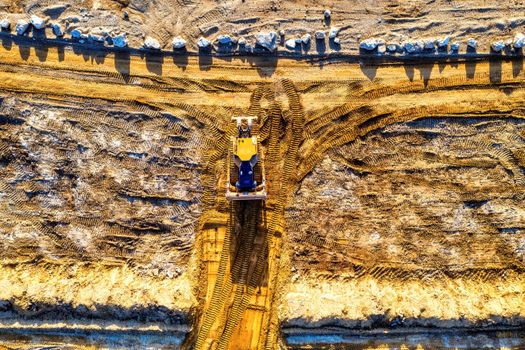 A drone captures an excavator working on a sandy construction site in Rochester, MN.
