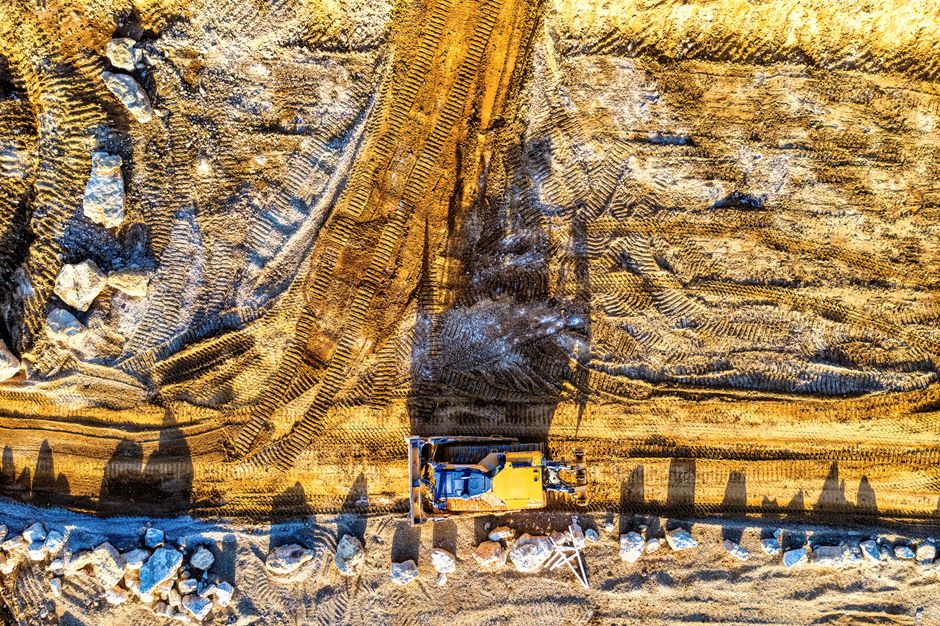An excavator performing precision grading on a large construction site - grading and paving companies near me An excavator performing precision grading on a large construction site - grading and paving companies near me