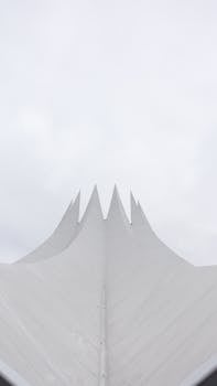 Minimalist view of a spiky architectural structure in Berlin with cloudy skies.