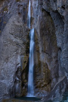 Stunning vertical waterfall flowing through rocky formations in Tirol, Austria.