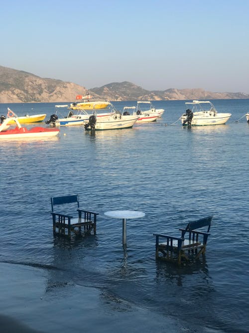 Photo of a Chairs and Table Awashing by the Sea