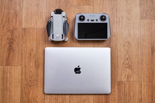 Free Overhead shot of a drone, controller, and laptop on a wooden floor Stock Photo