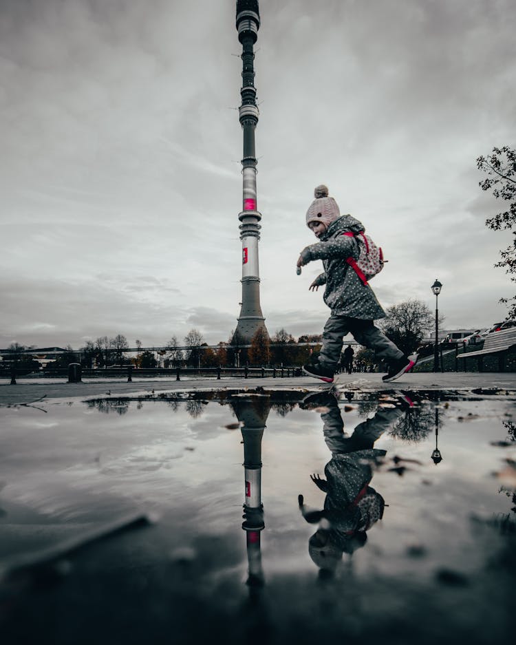 A Kid Carrying Backpack Walking On The  Street 