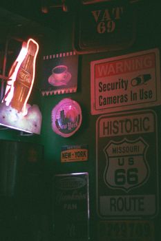 Collection of vintage signs in a dimly lit bar corner with a retro vibe.