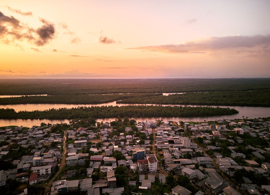 Stunning aerial view of Douala, Cameroon at sunset showcasing the river and urban landscape.
