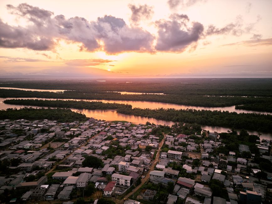 Stunning aerial view of Douala, Cameroon at sunset with lush rivers and vibrant sky.
