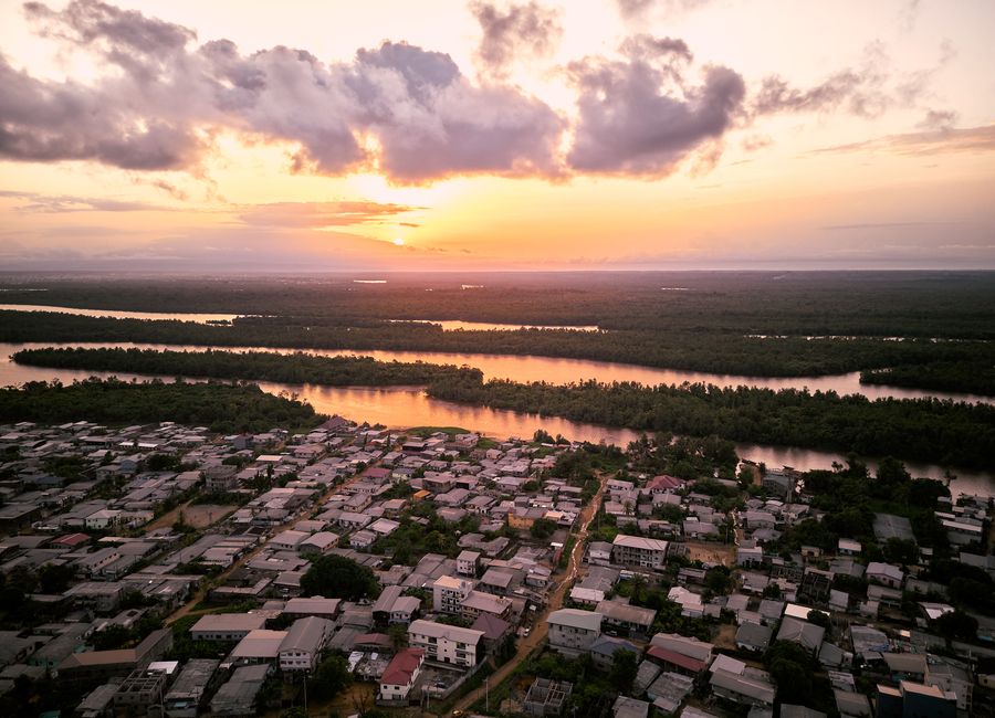 Stunning aerial view of Douala, Cameroon at sunset with lush rivers and vibrant sky.