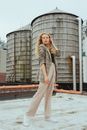 Woman in Black and White Stripe Long Sleeve Shirt and White Pants Standing on Swimming Pool