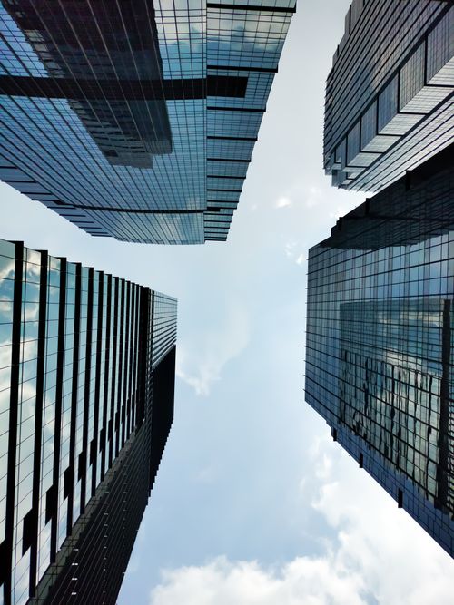 Free Upward view of modern skyscrapers against a clear sky in an urban setting. Stock Photo