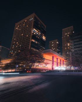 Illuminated Miyana shopping center and skyscrapers at night in Mexico City.