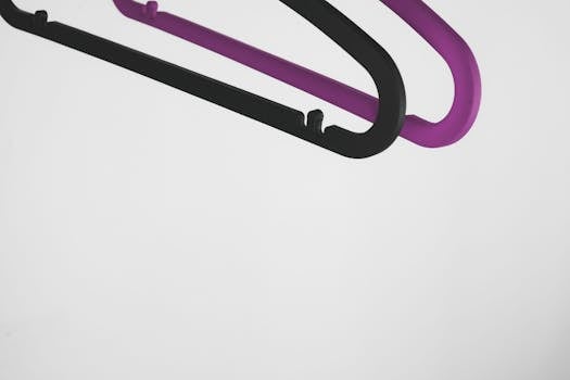 一张以白色为背景、搭配黑色和紫色衣架的极简主义照片，突出了设计与简洁感