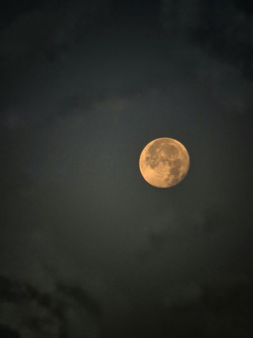 Free A full moon captured in the dark, cloudy night sky, highlighting celestial beauty. Stock Photo