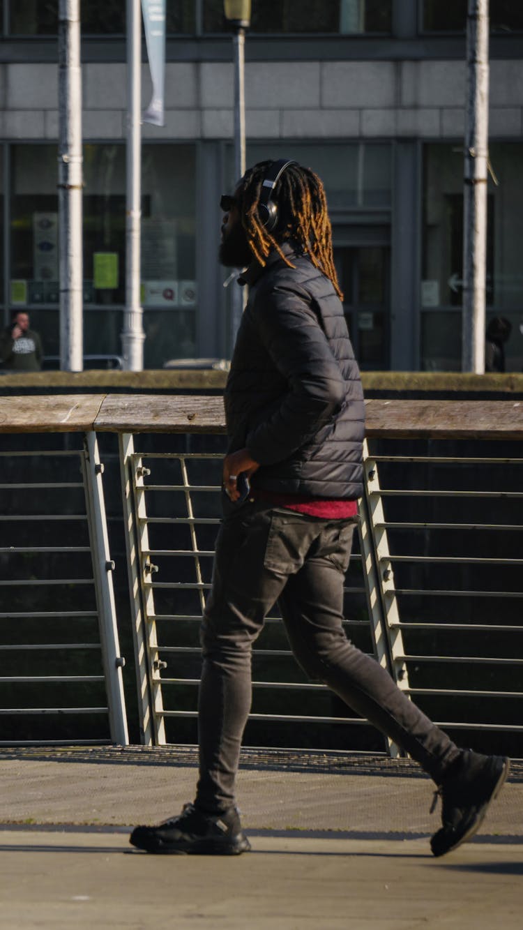 A Man Wearing Headphones While Walking