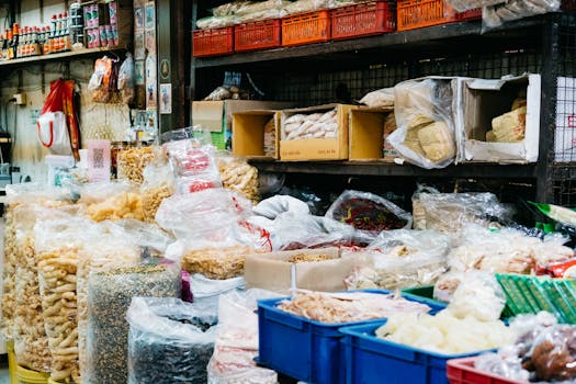 Colorful street market stall displaying a variety of dry foods in bags and boxes.