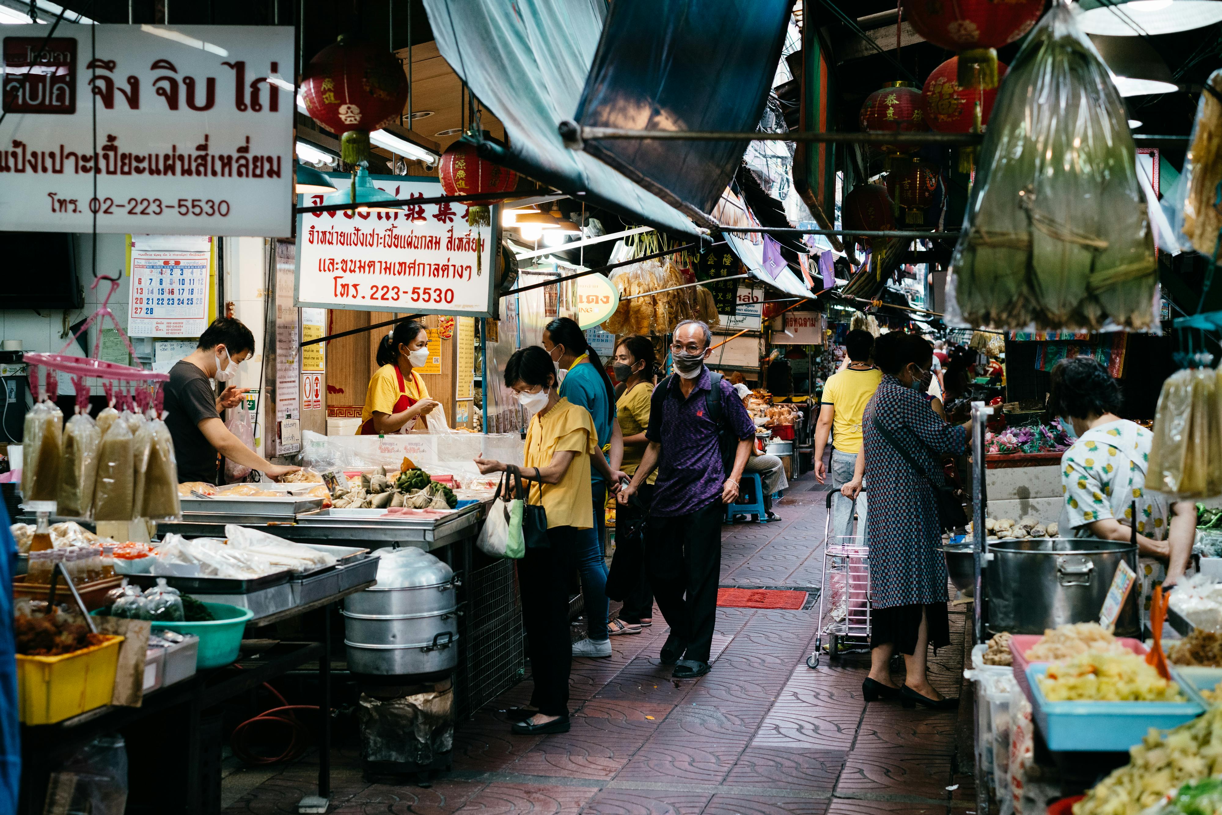 people shopping on a street market in thailand