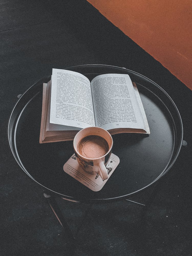 Book And Mug Of Coffe On Table