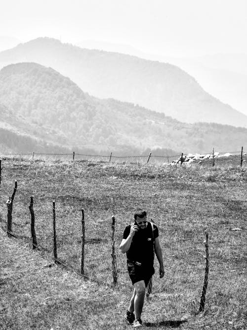 Foto profissional grátis de andando, conversando, escala de cinza