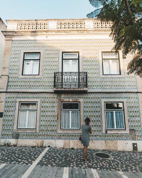 Woman Standing and Looking at a Building with a Pattern on the Facade in Lisbon, Portugal 