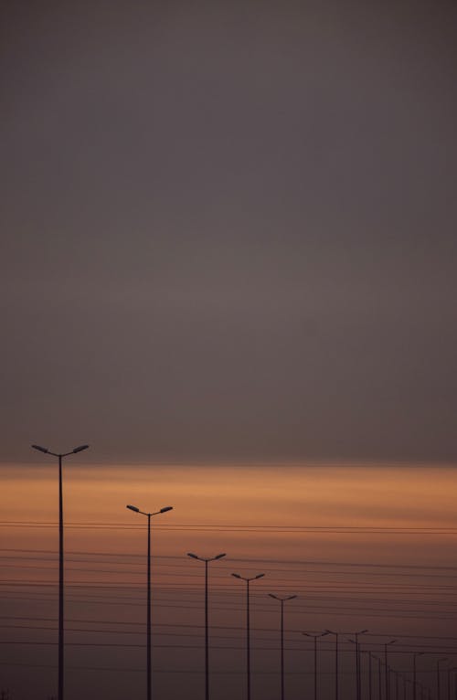 Безкоштовне стокове фото на тему «вертикальні постріл, вуличні ліхтарі, Захід сонця»