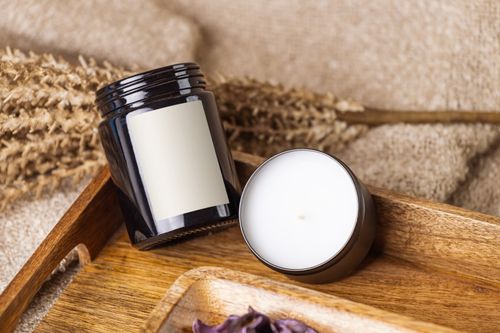 Free Close-up of a candle and jar arranged on a wooden tray with natural dried plants. Stock Photo