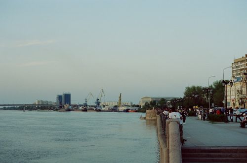 Free Peaceful urban harbor with cranes and promenade at dusk, bustling with city life. Stock Photo