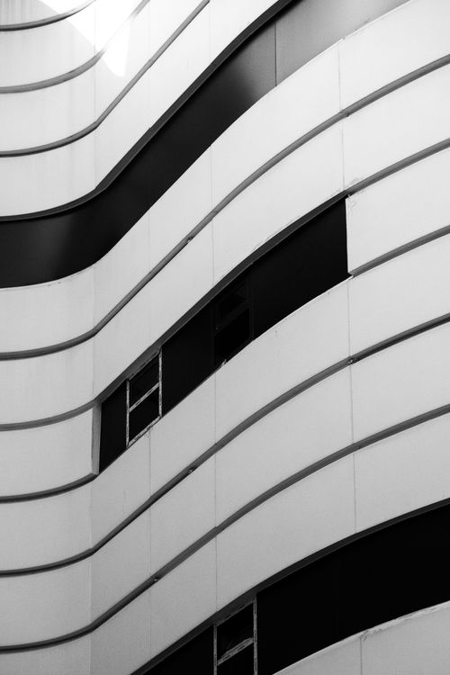Free Striking black and white abstract view of a modern building's exterior with curved lines. Stock Photo